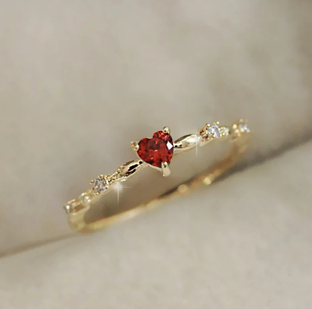 Bague d'amour dorée avec cœur rouge